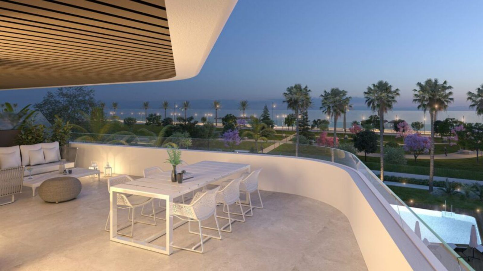 Balcon moderne avec table à manger, sièges lounge, et vue océan au crépuscule.