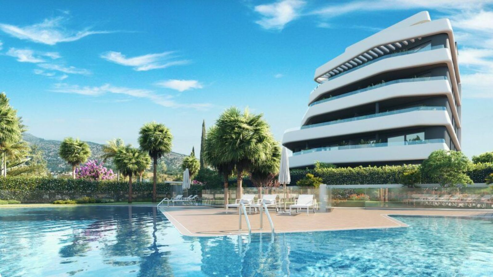 Immeuble moderne avec piscine, palmiers, et vue montagne sous ciel bleu.